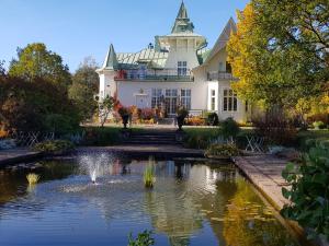 duży biały dom ze stawem i fontanną w obiekcie Villa Gransholm w mieście Gemla