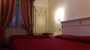 een hotelkamer met 2 bedden en een raam bij Hotel Quadrifoglio by Mancini in Rome