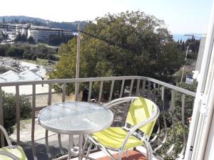 einen Tisch und Stühle auf einem Balkon mit Aussicht in der Unterkunft Guest House Villa Bellevue in Cavtat