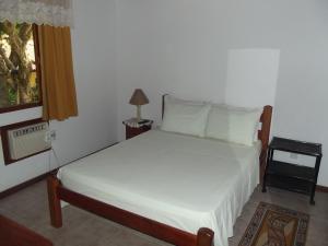 a bedroom with a bed and a window at Pousada Flats Paguru in Búzios