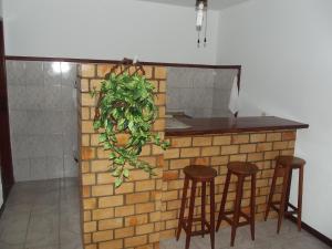 a kitchen with two bar stools and a counter top at Pousada Flats Paguru in Búzios