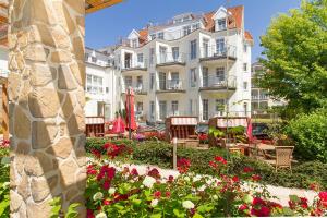 ein großes weißes Gebäude mit Blumen davor in der Unterkunft HOTEL am STRAND in Kühlungsborn