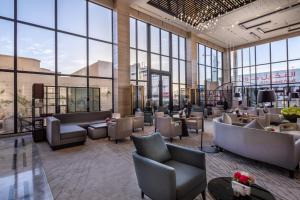 a lobby with chairs and tables and large windows at Braira Al Nakheel in Riyadh