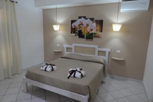 a bedroom with a bed with two towels on it at Villa Saturno in Tropea