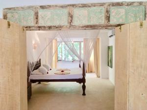 um quarto com uma cama de dossel e uma janela em White Elephant Sea Lodge em Melinde