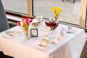 een witte tafel met bloemen en bekers erop bij Copthorne Hotel Merry Hill Dudley in Dudley