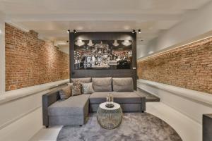 - un salon avec un canapé et un mur en briques dans l'établissement Luxury Canal Suite De Heren, à Amsterdam