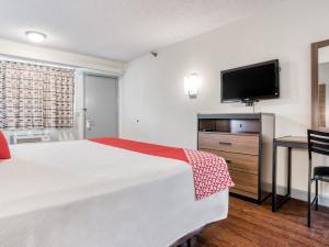 een hotelkamer met een bed, een bureau en een televisie bij Dallas Love Field Inn in Dallas