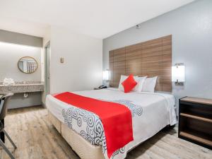 een hotelkamer met een groot bed met een rode deken bij Dallas Love Field Inn in Dallas