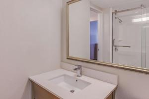 a bathroom with a sink and a mirror at La Quinta by Wyndham Philadelphia Airport in Essington