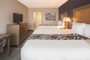 a hotel room with two beds and a flat screen tv at La Quinta by Wyndham Philadelphia Airport in Essington