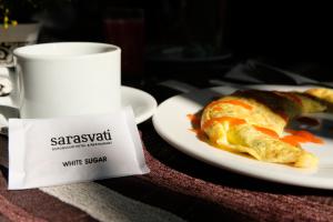 een tafel met een bord eten en een kopje bij Sarasvati Borobudur in Borobudur