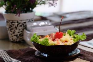 een kom salade met een kers op een tafel bij Sarasvati Borobudur in Borobudur