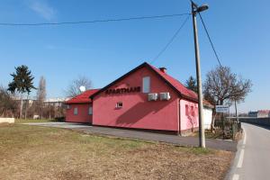 un edificio rojo al lado de una carretera en Apartman Kupa, en Karlovac