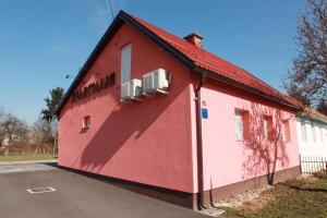 un edificio rojo con techo rojo en una calle en Apartman Kupa, en Karlovac