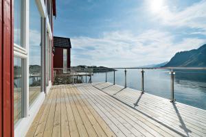 eine Holzterrasse mit Blick auf das Wasser in der Unterkunft Lofoten Waterfront luxury lodge in Ballstad