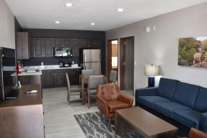 a living room with a blue couch and a kitchen at Zion Canyon Lodge in Springdale