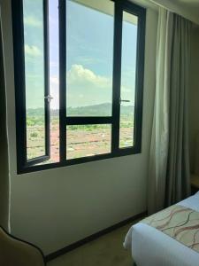 una camera da letto con finestra affacciata su un campo di Purest Hotel Sungai Petani a Sungai Petani