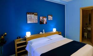 a blue bedroom with a bed and a blue wall at Zama Bed&Breakfast in Scalea