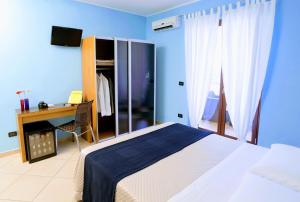 a bedroom with a bed and a desk with a computer at Zama Bed&Breakfast in Scalea