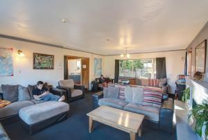 a man sitting on a couch in a living room at The Flaming Kiwi Backpackers in Queenstown