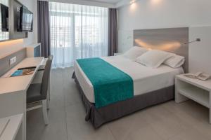 Pokój hotelowy z łóżkiem, biurkiem i komputerem w obiekcie Hotel Olympus Palace w Salou