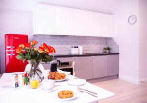 a kitchen with a table with a vase of flowers at Quiet Central West End Apartments by Indigo Flats in London