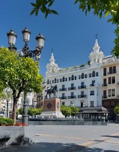 un edificio con una estatua delante de él en H10 Palacio Colomera, en Córdoba