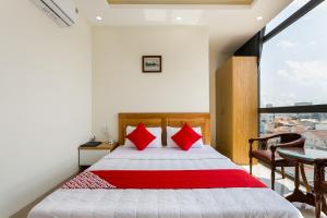 - une chambre avec un lit doté d'oreillers rouges et une fenêtre dans l'établissement Marine Hotel & Apartment, à Vung Tau