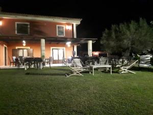 un groupe de chaises longues devant une maison la nuit dans l'établissement Casale degli Ulivi, à Cirò Marina