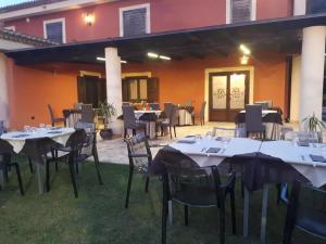 un groupe de tables et de chaises devant un bâtiment dans l'établissement Casale degli Ulivi, à Cirò Marina