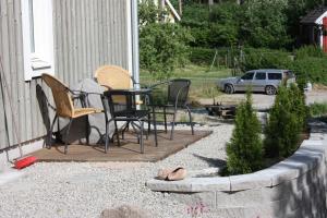 a patio with chairs and a table on the side of a house at Långesjö lillstuga in Fjällbacka