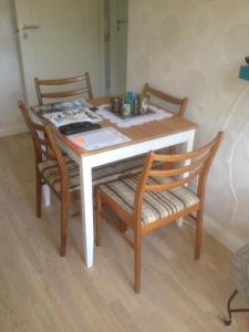 a table with two chairs and a white table and chairs at Långesjö lillstuga in Fjällbacka