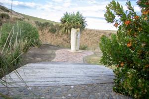 a stone statue on a walkway in a field at Old Bones Lodge in Oamaru