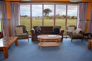 a living room with a couch and chairs and a table at Old Bones Lodge in Oamaru