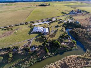 an aerial view of a house on a farm next to a river at Old Bones Lodge in Oamaru