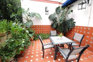 un patio con mesa, sillas y plantas en Hotel Casa de los Azulejos, en Córdoba