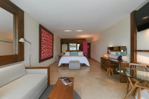 A bed or beds in a room at Hotel Xcaret Mexico All Parks All Fun Inclusive