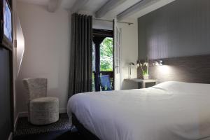 a hotel room with a bed and a window at Hotel Restaurant Père Benoît in Entzheim