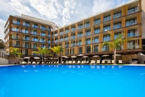 un gran edificio con una gran piscina azul frente a él en Golden Costa Salou - Adults Only 4* Sup, en Salou