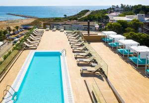 una piscina con tumbonas y la playa en Golden Costa Salou - Adults Only 4* Sup, en Salou