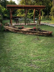 cenador de madera con mesa de picnic en un parque en Apartman Kupa, en Karlovac