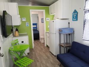 a kitchen with a blue chair and a refrigerator at Tiny House Siesta in Sarasota