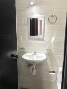 a bathroom with a sink and a mirror on the wall at HOTEL LOS PINOS CENTRO in Tuxtla Gutiérrez