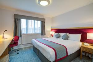 a hotel room with a large bed and a desk at Warwick Conferences - Radcliffe in Coventry