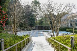 uma passarela num parque com árvores e um edifício em Narita Tobu Hotel Airport em Narita