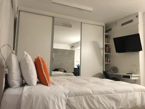 1 dormitorio con 1 cama blanca grande con almohadas en Loft Confortável e Moderno, en São Paulo