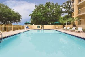 a large blue pool with chairs and umbrellas at Days Inn by Wyndham Gainesville Florida in Gainesville