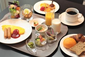 einen Tisch mit Frühstücksteller und Gläsern Milch in der Unterkunft Piazza Hotel Nara in Nara