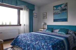 - une chambre avec un lit doté d'une couverture bleue et d'une fenêtre dans l'établissement Villa Paradiso, à Sirmione